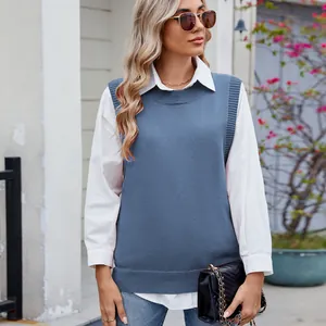 Close-up detail of a casual blue knit vest layered over a crisp white long-sleeve shirt