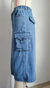 Gros plan détaillé sur la poche cargo d'une jupe midi en jean bleu clair sur mannequin.