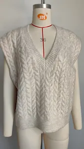 Close-up of a cream-colored V-neck cable knit sweater vest on a mannequin