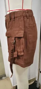 Close-up detail of brown American style denim cargo shorts with elastic waist and large pocket.