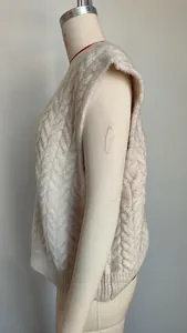 Side detail of a cream retro cable-knit V-neck sleeveless sweater vest on mannequin