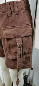 Detail shot of brown denim cargo shorts featuring a D-ring pocket and stylish strap.