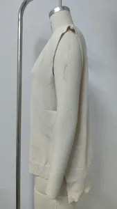 Detailansicht der Seitenprofils und des Rippsaums einer cremefarbenen Strickweste.