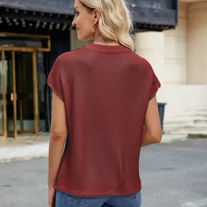 Rückansicht einer Frau in einem kastanienbraunen kurzärmeligen Strickpullover in der Stadt
