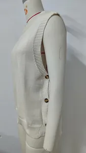 Close-up of white knitted vest with side button details and split hem