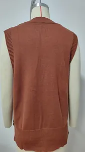 Back view of a solid rust orange knit sweater vest featuring a ribbed hem and button detail.