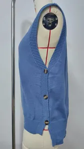 Side view of blue knitted vest featuring decorative buttons and a stylish side slit