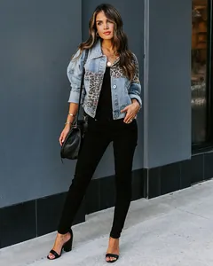 Fashionable leopard print patchwork distressed denim jacket worn by a model outdoors