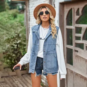 Stylish women's loose denim vest worn over a white sweatshirt in a street scene