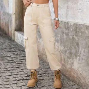 Detail view of beige denim cargo pants with side pockets and elasticated hem