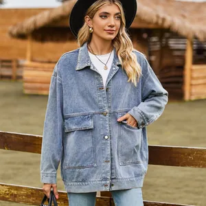 Full-length view of an oversized light blue denim jacket worn by a model in a ranch setting.