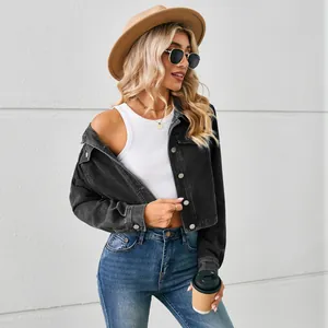 Lifestyle view of a cropped washed black denim jacket paired with a white tank top