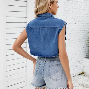 Back view of a cropped blue denim vest with collar, worn with distressed shorts.