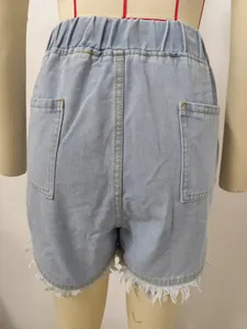 Detailed back view of light blue denim shorts with elastic waist and frayed hem.