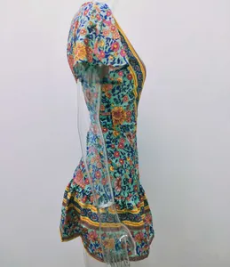Seitenprofil eines lebhaften Bohème-Minikleids mit Blumendruck und V-Ausschnitt am Mannequin.