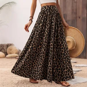 Detail of a leopard print maxi skirt with an A-line silhouette on a sunlit beach.