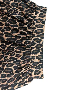 Close-up detail of leopard print skirt showing waistband and pleated fabric texture