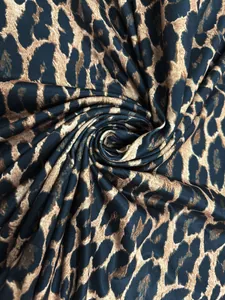 Close-up view of elegant leopard print fabric texture showing spiral textile detail.