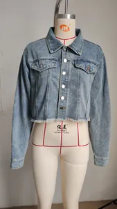 Vista dettagliata della giacca corta in denim con bottoni metallici e orlo a frange