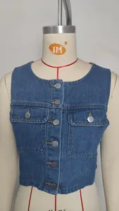 Detail of a washed blue denim vest featuring silver buttons and chest pockets