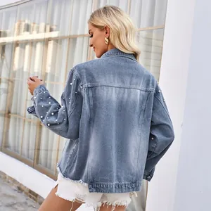 Detailansicht der Rückseite einer Jeansjacke mit eleganten Perlenstickereien an Ärmeln.