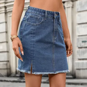 Detailed macro view of washed blue denim mini skirt featuring front slit and raw fringe hem