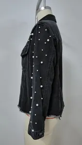 Nahaufnahme des Ärmels einer schwarzen Jeansjacke mit eleganten weißen Perlendetails