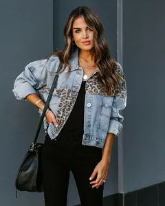 Detail of distressed denim jacket featuring leopard print panel and metal buttons.
