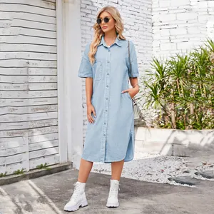 Blonde model posing in a light blue washed denim short sleeve midi shirt dress outdoors