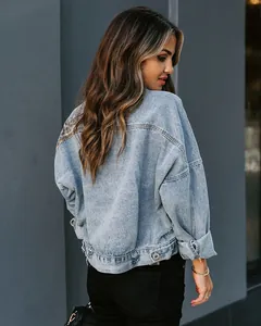 Back view of light blue denim jacket featuring leopard print patchwork and distressed details