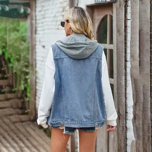 Back view of a casual oversized light blue denim vest layered over a white hoodie.
