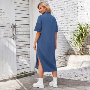 Back view of a loose washed blue denim maxi dress with side slits and short sleeves.