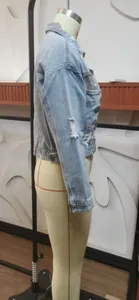 Side view detail of distressed denim jacket with leopard print and ripped sleeve