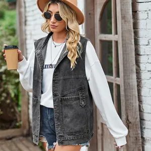 Detail view of women's loose oversized dark grey denim vest in outdoor lifestyle setting