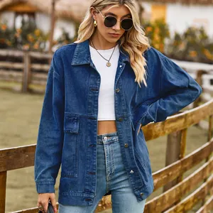 Classic oversized blue denim jacket for women with pockets in outdoor ranch setting