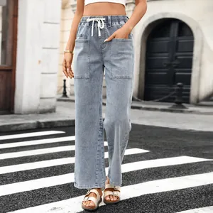 Detailed view of high-waist washed denim pants with drawstring and pockets.