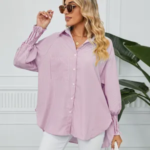 Détail d'une chemise rayée pour femme avec poignets plissés et coupe ample.