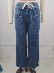 Front view of blue denim drawstring pants with large pockets and elastic waist band.