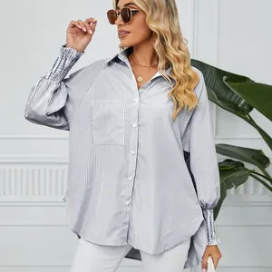 Détail des poignets smockés sur une chemise à rayures bleues et blanches oversize