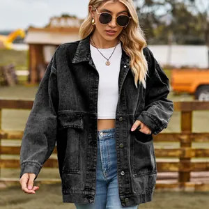 Detail of oversized black denim jacket with large pockets and classic metal buttons