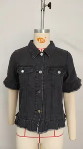 Close-up detail of washed black denim jacket featuring ruffled hem and short sleeves