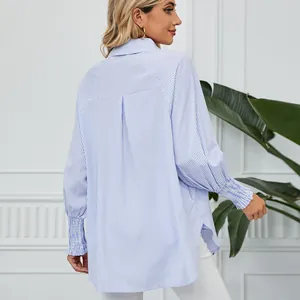 Vue détaillée du dos et des poignets smockés d'une chemise rayée bleue et blanche