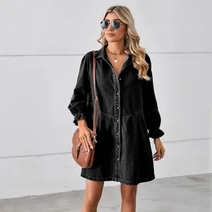 Detail of a loose black washed denim long sleeve dress with ruffled cuffs and collar.