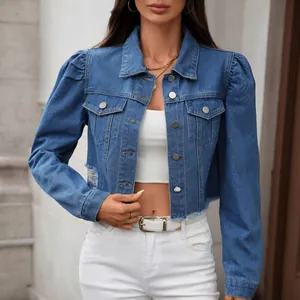 Detailed close-up view of a washed blue denim jacket featuring puff sleeves and raw edges