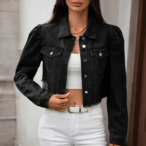Detail of a black washed denim jacket featuring puff sleeves and a trendy frayed hem.