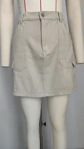 Détail de la mini-jupe cargo beige montrant les poches et la texture du denim délavé