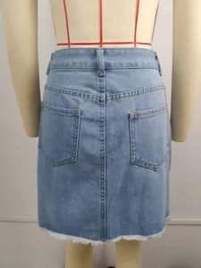 Detail view of light blue washed denim mini skirt with frayed hem and back pockets.