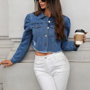 Detail of a chic washed puff sleeve cropped denim jacket with trendy raw hem finish