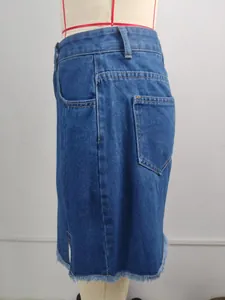 Detailed view of fashionable blue denim mini skirt with side split and frayed hem.
