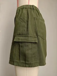 Gros plan détaillé sur une jupe cargo en jean vert olive avec poches latérales